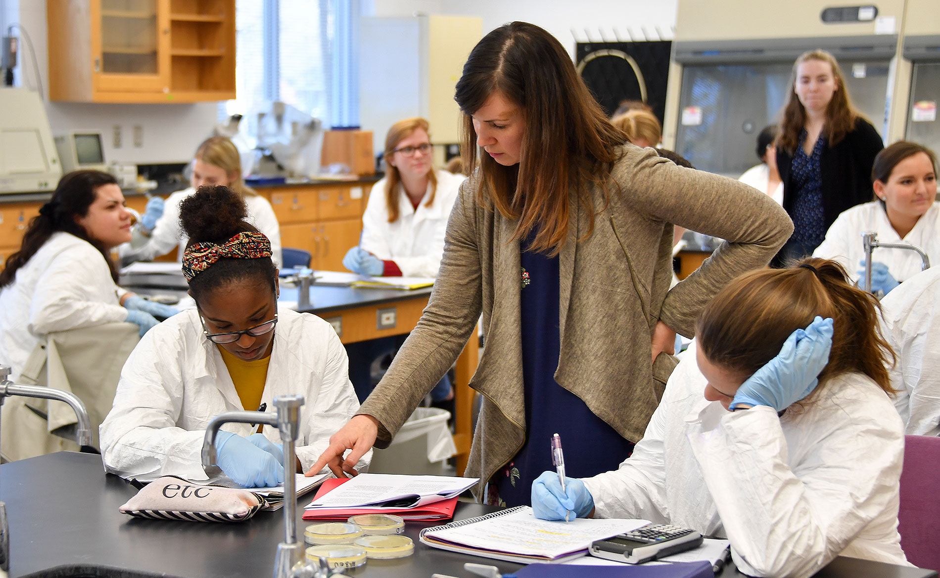 Professor working with students in a lab