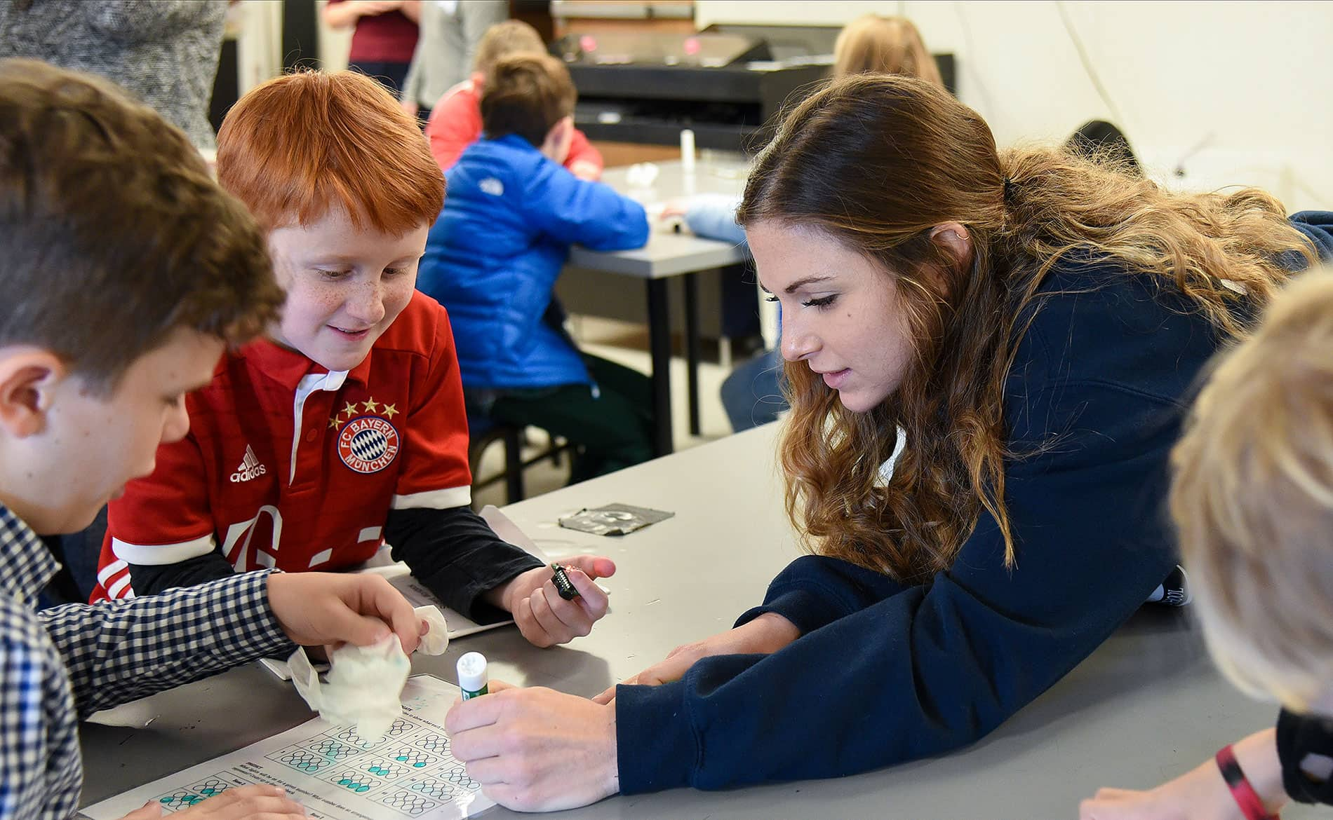 Student working with young children in an educational setting