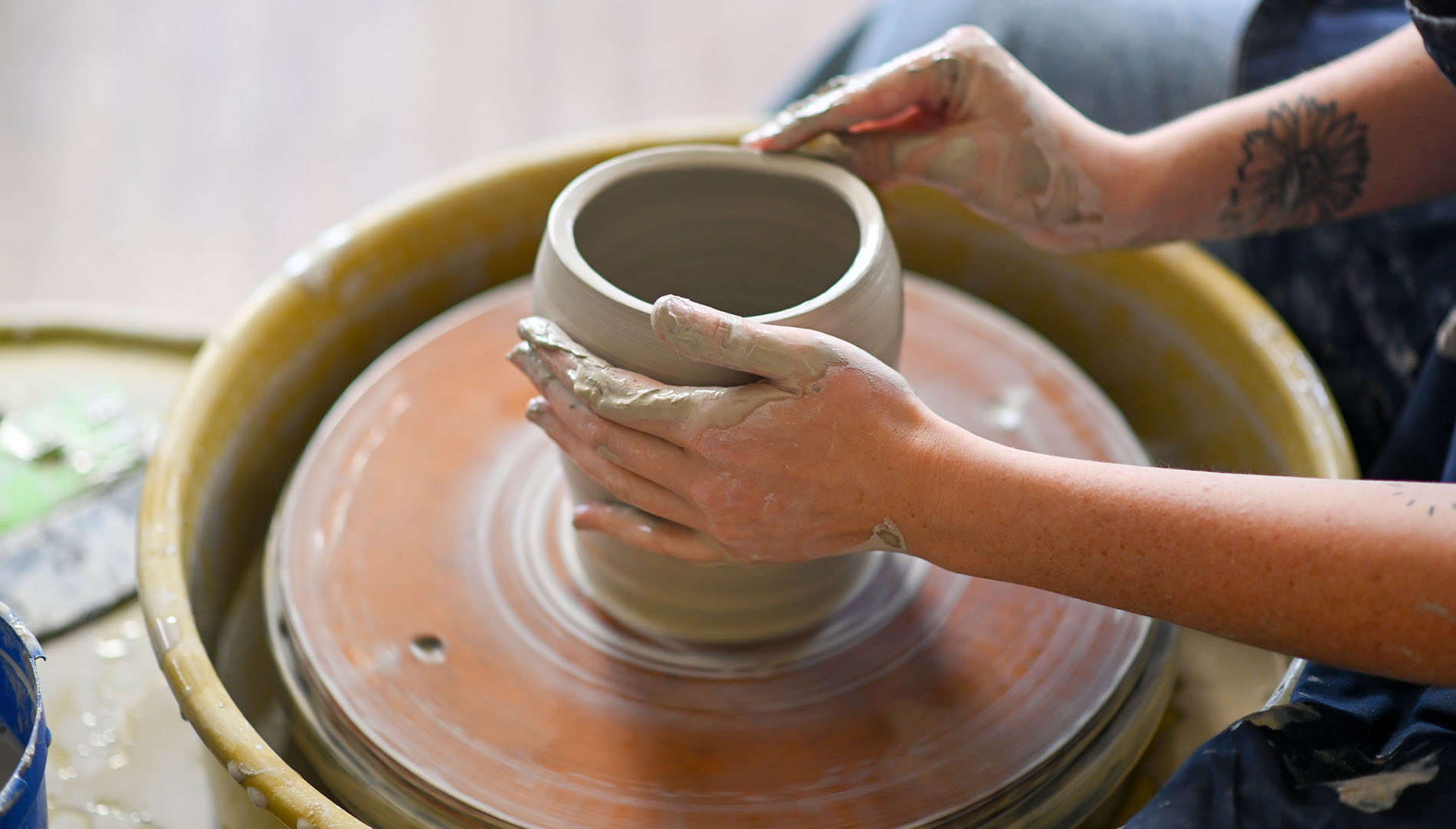 student using pottery wheel